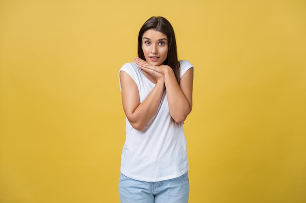 Mooie jonge vrouw in wit overhemd houdt hoofd in handen glimlachend en kijkend naar camera