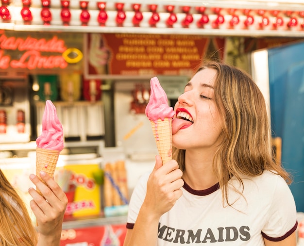 Gratis foto mooie jonge vrouw likken lekker ijs