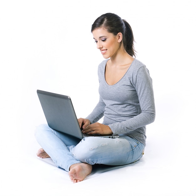 Mooie jonge vrouw met laptop in de studio