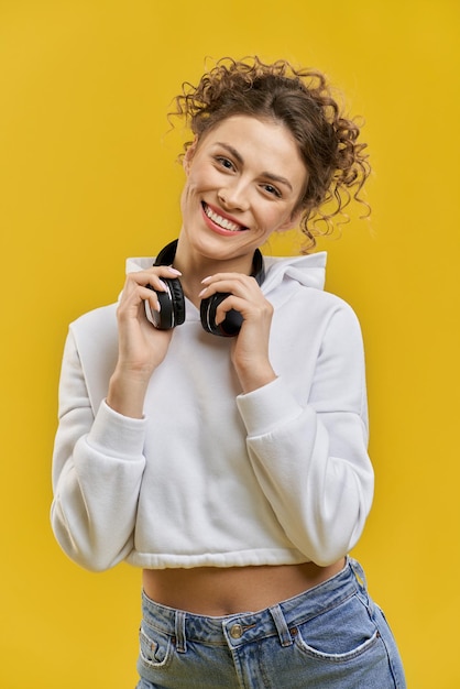 Gratis foto mooie jonge vrouw met oortelefoons op nek