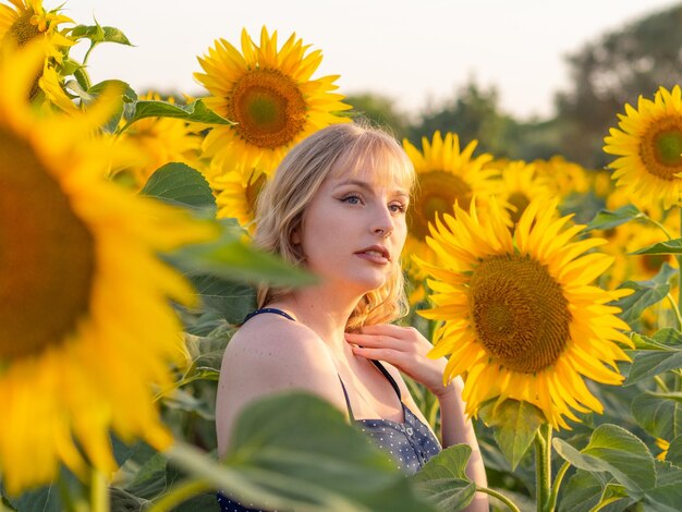 Mooie jonge vrouw midden in een zonnebloemveld