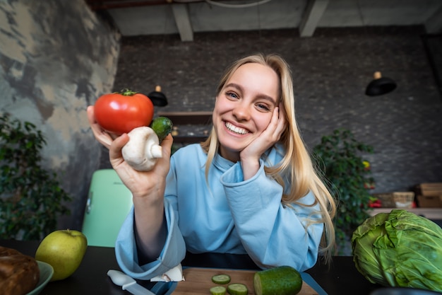 Mooie jonge vrouw poseren in de keuken