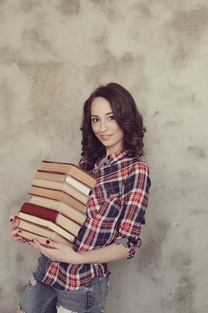 Mooie jonge vrouw poseren met boeken