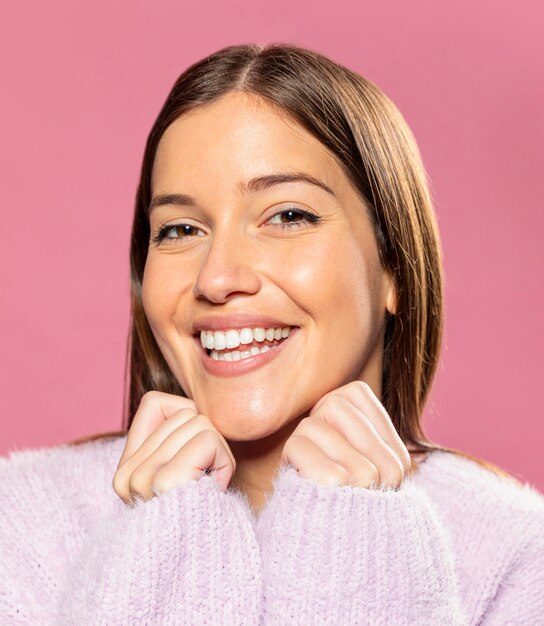 Mooie jonge vrouw poseren met roze behang in de rug