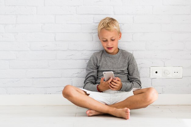 Mooie kleine jongen met behulp van zijn smartphone