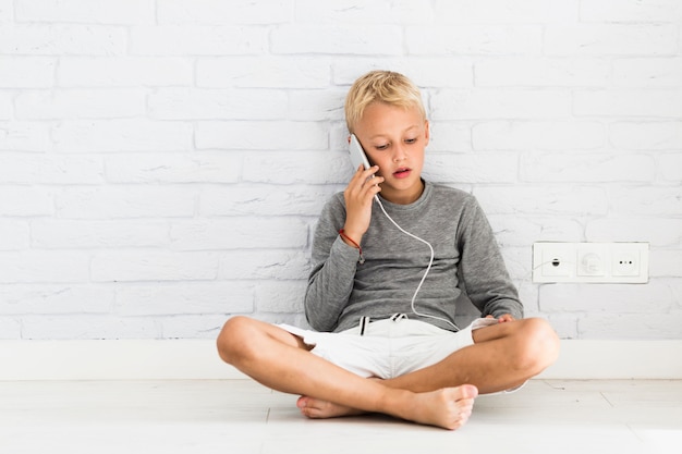 Mooie kleine jongen met behulp van zijn smartphone