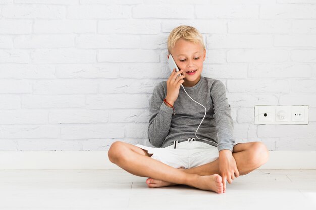 Mooie kleine jongen met behulp van zijn smartphone