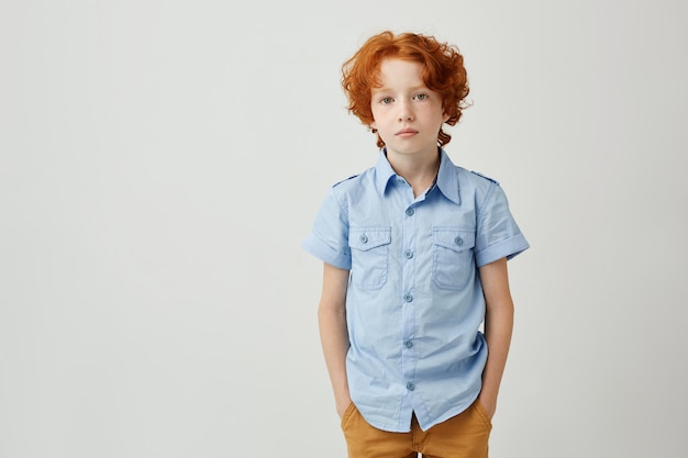 Mooie kleine jongen met gember haar en sproeten hand in hand in de zak