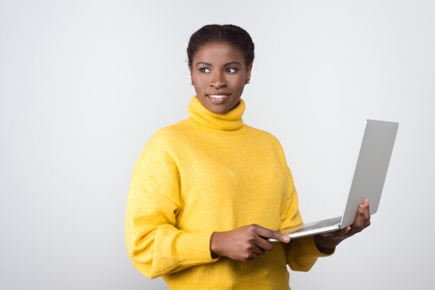 Mooie lachende Afro-Amerikaanse vrouw met laptop