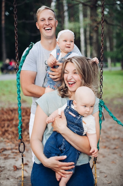 Gratis foto mooie mama, papa en twee blanke kinderen hebben samen plezier en glimlachen buiten