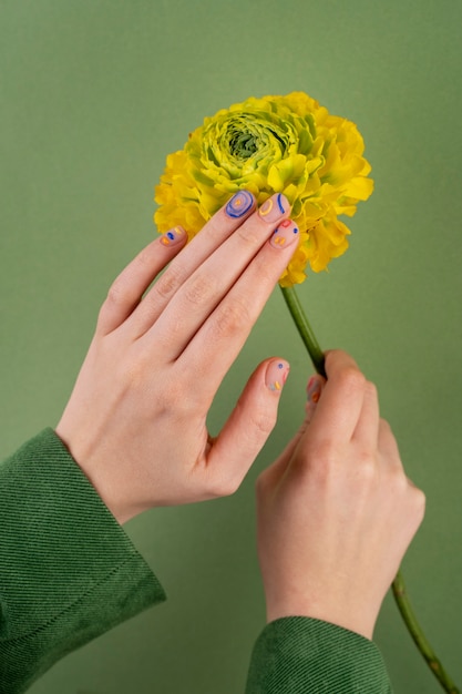 Mooie manicure en gele bloem close-up