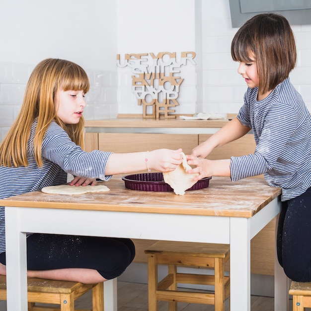 Gratis foto mooie meisjes die deeg in handen samen houden