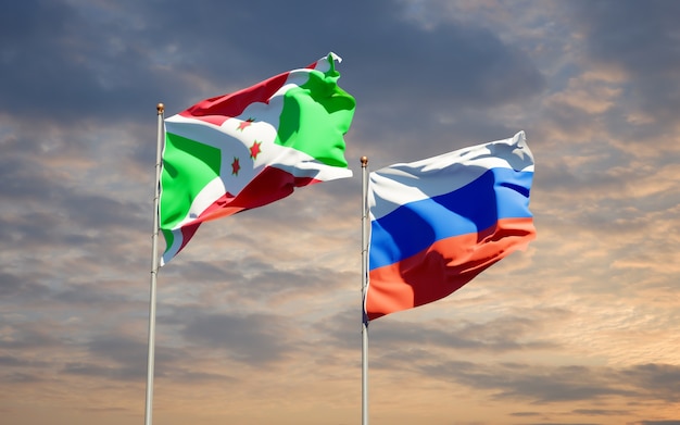 Mooie nationale vlaggen van rusland en burundi samen op blauwe hemel. 3d-illustraties