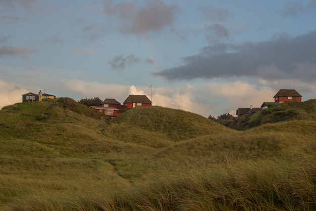 Mooie opname van huizen bovenop heuvels met dunne wolken