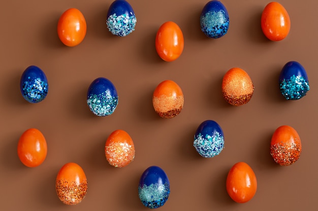 Mooie pasen met oranje en blauwe decoratieve eieren in pailletten.