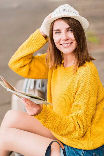 Mooie reizende vrouw die de camera onder ogen ziet