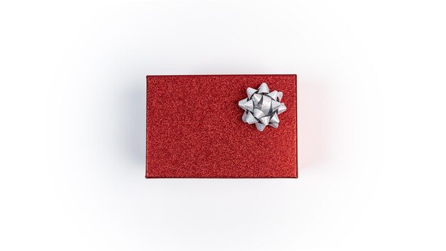 Mooie rode doos cadeau met zilveren boog kerstdecoratie geïsoleerd op een witte achtergrond. xmas ornamenten met kopie ruimte voor tekst. nieuwjaar realistisch decorontwerpelement voor vieringskaart of flyer Premium Foto