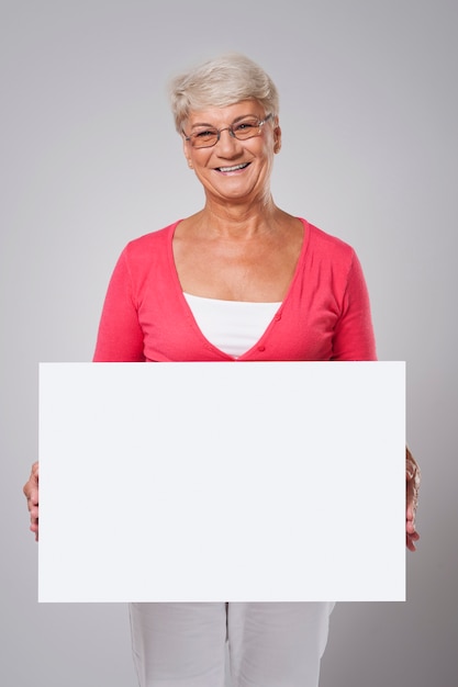 Mooie senior vrouw die door whiteboard