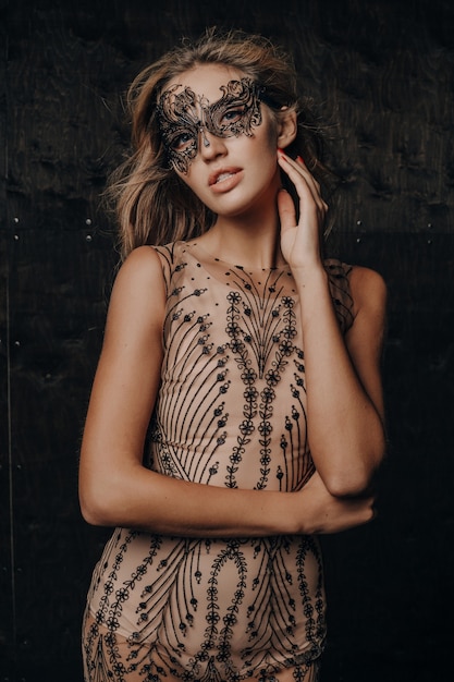 Mooie sexy model vrouw in luxe kanten avondjurk poseren in carnaval masker