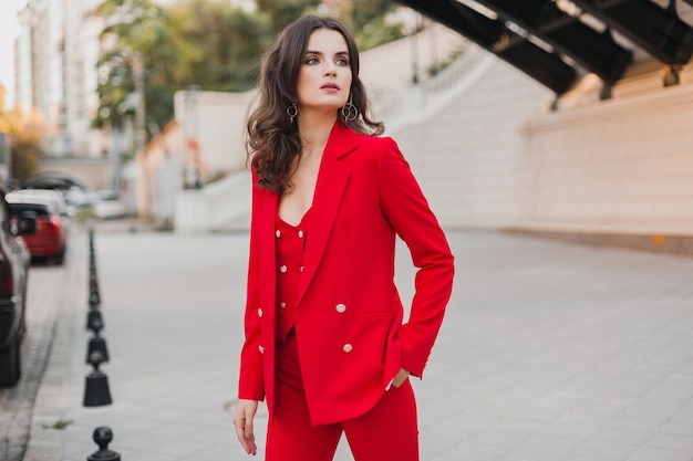 Mooie sexy rijke zakenvrouw in rood pak wandelen in de stad straat, lente zomer modetrend