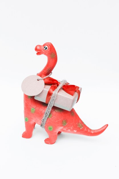 Mooie speelgoeddinosaurus met Kerstmisgift