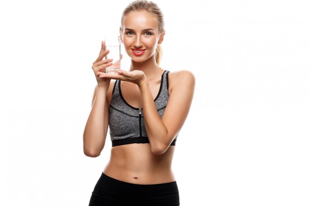 Mooie sportieve vrouw poseren, met een glas water