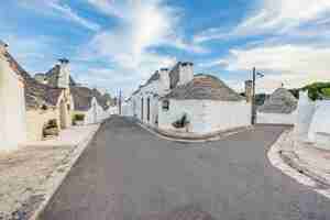 Gratis foto mooie stad alberobello met trulli-huizen tussen groene planten en bloemen, belangrijkste toeristische wijk, regio apulië, zuid-italië. typische gebouwen gebouwd met droge stenen muren en kegelvormig dak