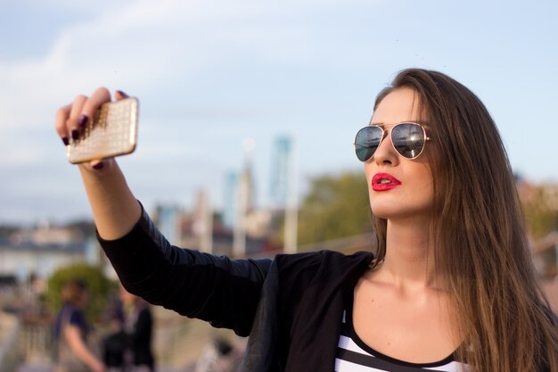 Mooie stedelijke vrouw genomen foto van zichzelf, selfie. Gefilterde afbeelding.