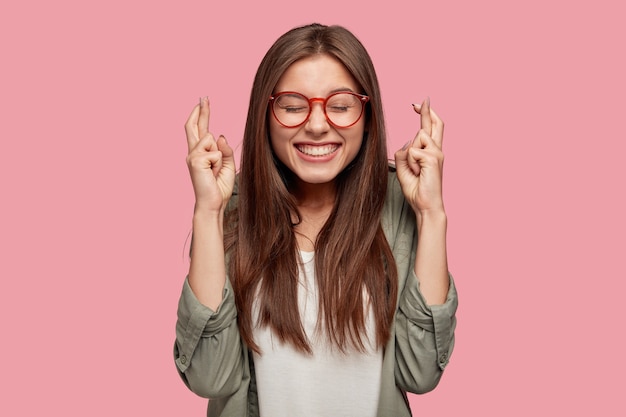 Mooie student poseren tegen de roze muur