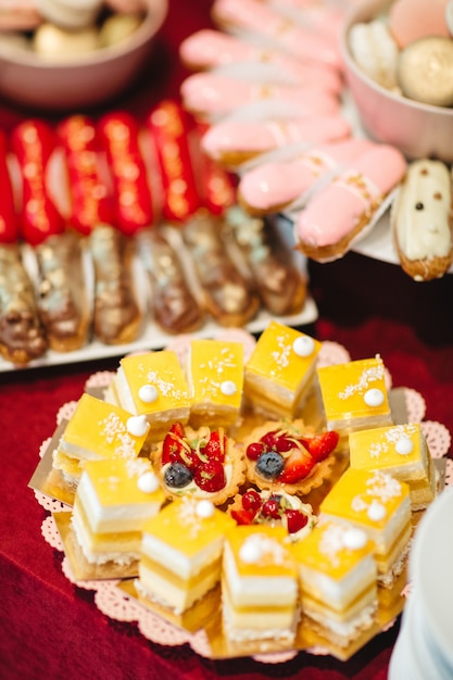 Mooie taarten staan op een bord op een feestelijke tafel