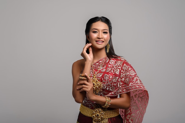 Mooie Thaise vrouw die een Thaise kleding en een gelukkige glimlach draagt.
