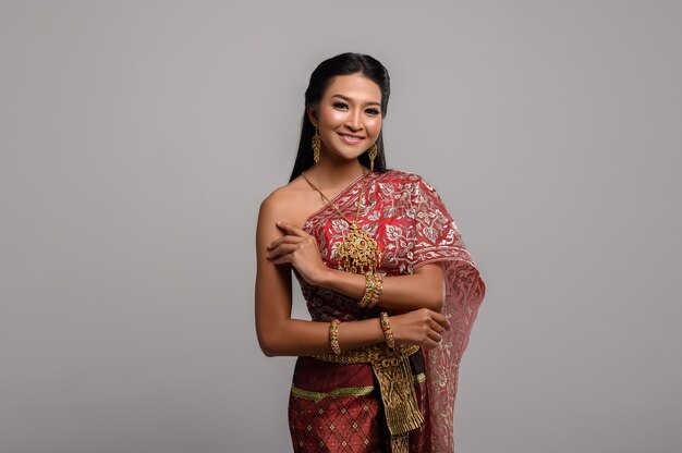 Mooie Thaise vrouw die een Thaise kleding en een gelukkige glimlach draagt.
