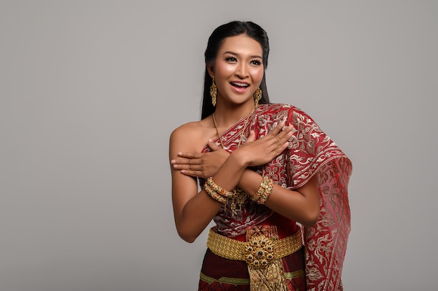 Mooie Thaise vrouw die een Thaise kleding en een gelukkige glimlach draagt.
