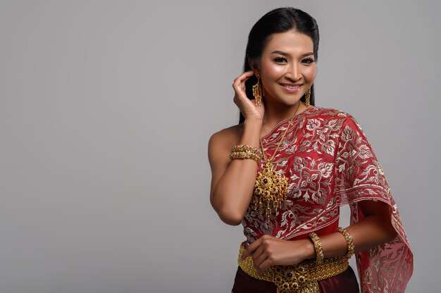 Mooie Thaise vrouw die een Thaise kleding en een gelukkige glimlach draagt.