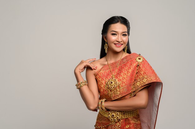 Mooie Thaise vrouw die een Thaise kleding en een gelukkige glimlach draagt.