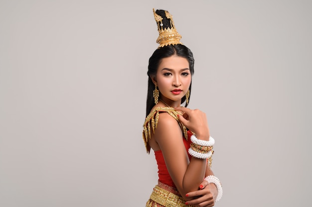 Mooie Thaise vrouw die Thaise kleding draagt en aan de kant kijkt