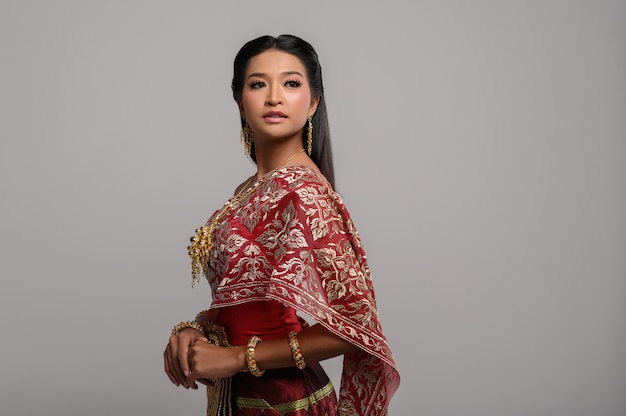 Mooie Thaise vrouw die Thaise kleding draagt en de bovenkant bekijkt
