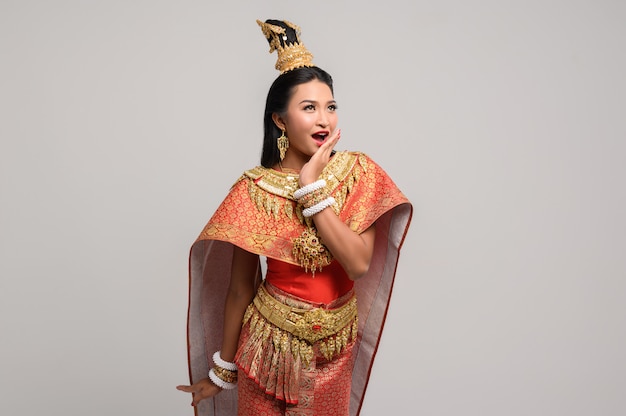 Mooie Thaise vrouw die Thaise kleding draagt en de bovenkant bekijkt
