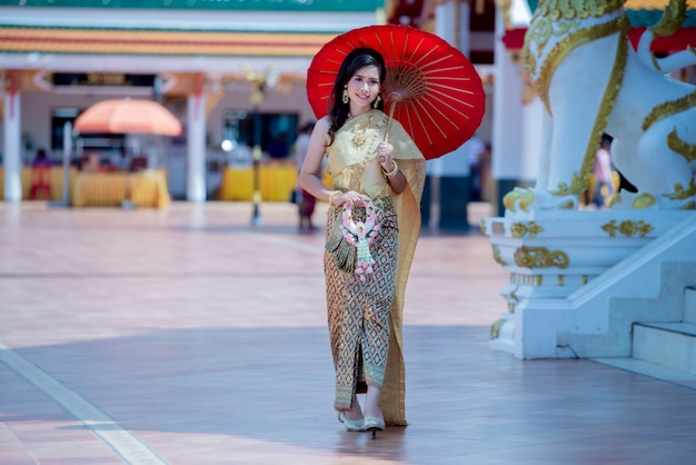 Gratis foto mooie thaise vrouw in traditioneel kledingskostuum in de tempel van phra that choeng chum thailand