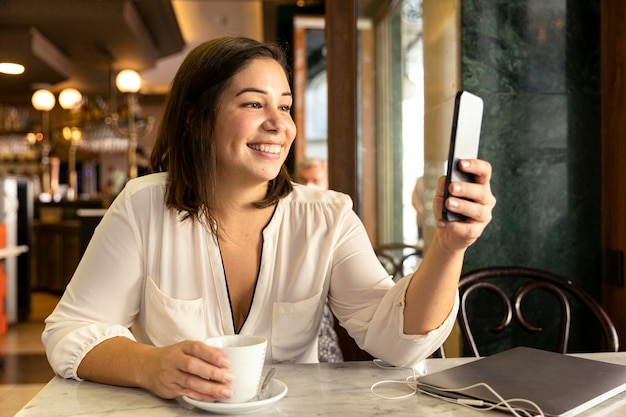 Gratis foto mooie tiener die haar mobiele telefoon doorbladert