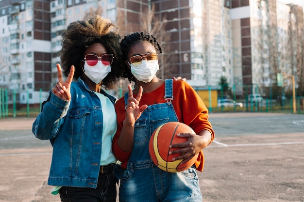 Gratis foto mooie tieners poseren met medische maskers