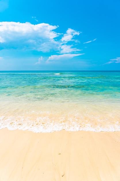 Mooie tropische lege strand zee oceaan met witte wolk op blauwe hemelachtergrond