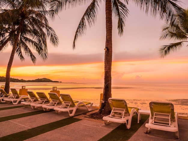 Gratis foto mooie tropische strandoverzees en oceaan met kokosnotenpalm in zonsopgangtijd
