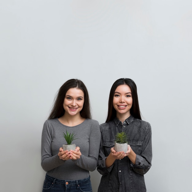 Mooie volwassen vrouwen die planten houden