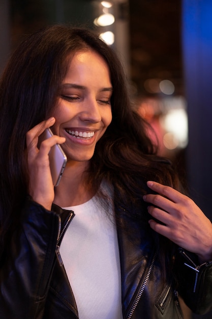 Mooie vrouw aan de telefoon tijdens een avondje uit