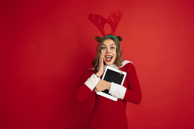 Mooie vrouw als kerst herten geïsoleerd op rood muur concept