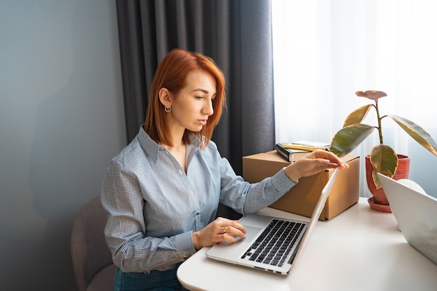 Mooie vrouw die aan laptop, mede-werkend gebied werkt