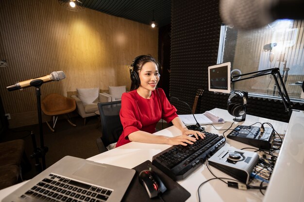 Mooie vrouw die bij radio met professionele apparatuur werkt