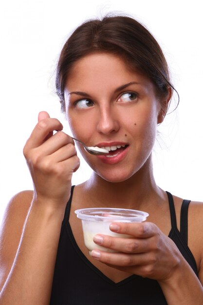 Mooie vrouw die dessert jogur eet