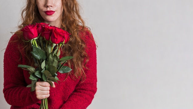 Mooie vrouw die een boeket rozen houdt